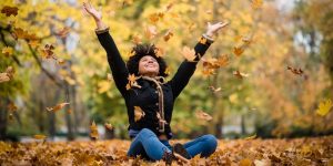 joyous teen playing with dry maple leaves picture id1016602340