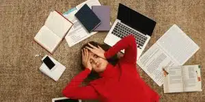 tired student girl lying on the floor with books and gadgets picture id932274694