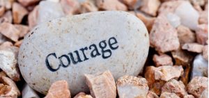 courage written on a big smooth rock with jagged rocks picture id153070738
