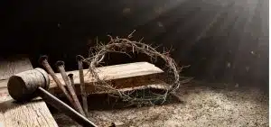 crown of thorns, nail, mallet, and thick nail in a pile on a dirt floor