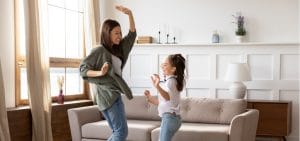 overjoyed-young-mommy-babysitter-dancing-to-music-with-girl-picture