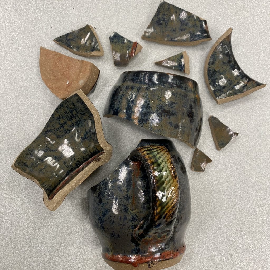 pieces of broken ceramic mug arranged neatly