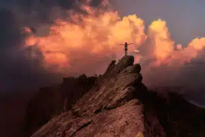 person standing on a mountain top with outstretched arms